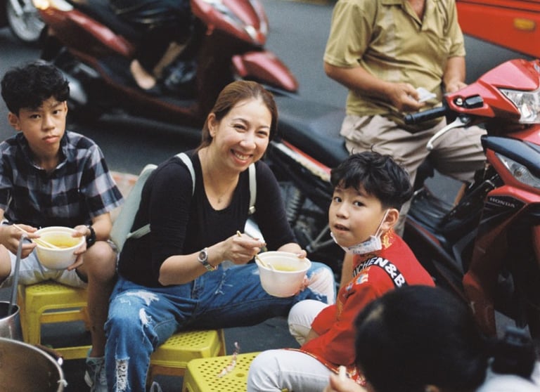 Vietnamese family having dinner on the pavement in Saigon