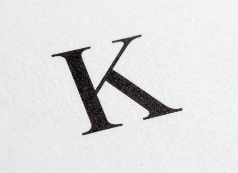 Macro shot of elegant black serif typography printed on high-quality matte white paper. Clean and minimal, International / General.