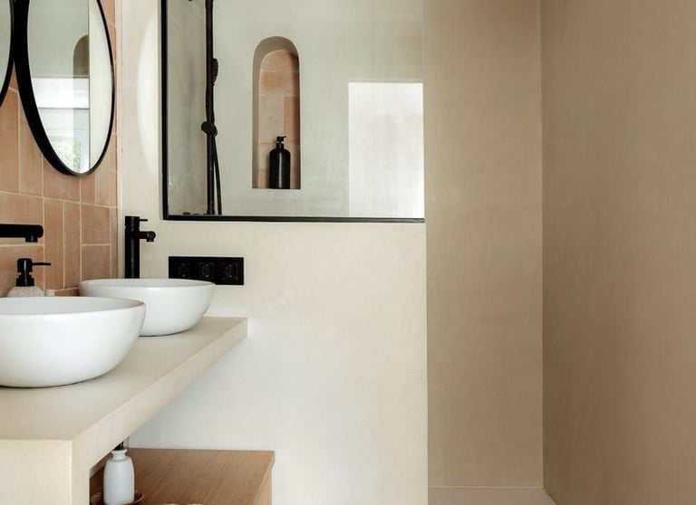 Modern bathroom with microcement walls, double sinks, terracotta tile flooring, and glass shower enc