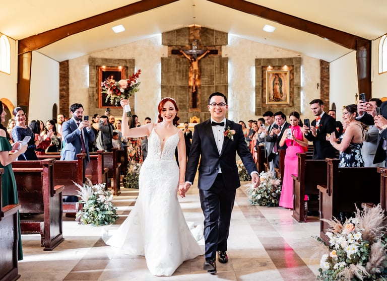 a bride and groom walking down the aisle of a church