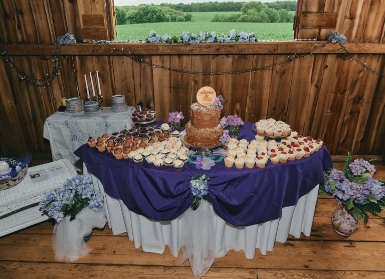 a table with a wedding cake and cupcakes on it