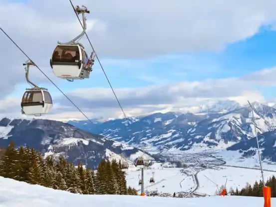 Ski gondola lift over snowy slopes at Zell am See Kaprun ski resort Austria.
