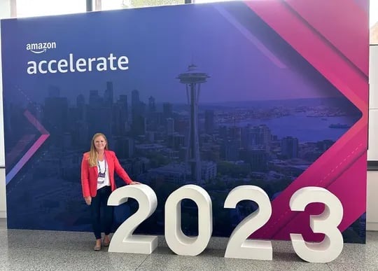 Colleen Quattlebaum standing in front of a sign that says, "Amazon accelerate 2023"