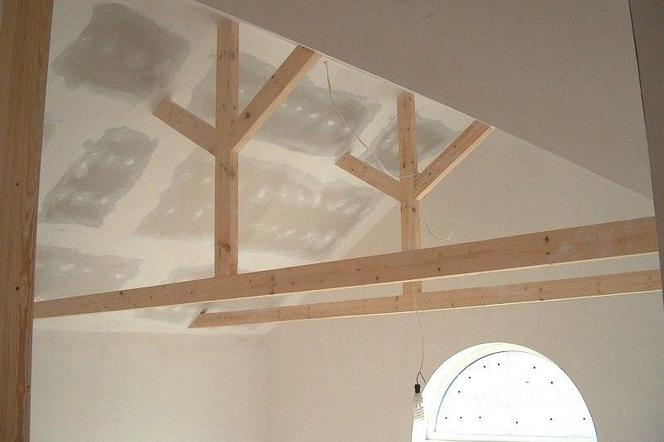 Gerenoveerd oud plafond van gipsplaten met zichtbare balken.