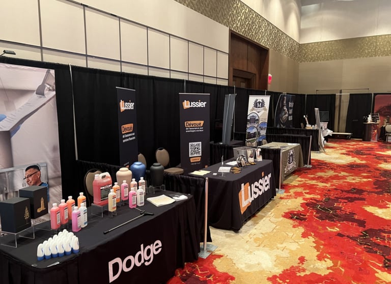 Dodge and Lussier exhibition booths at a professional convention with funeral supplies and banners.
