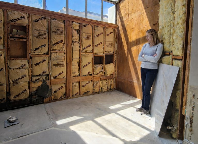 Teri Allen with RenoPLNR at a remodel job site during wall framing and insulation work
