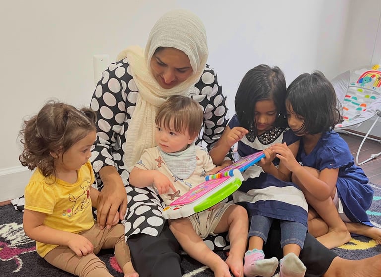 Caregiver and children reading an electronic book at daycare