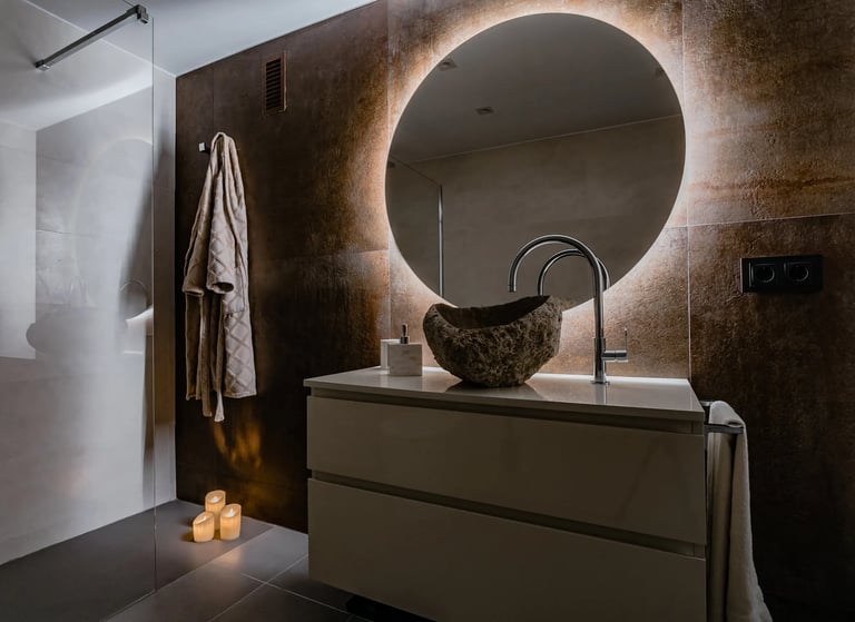 Reforma de baño de lujo con materiales naturales y lavabo en piedra, realizado por los mejores interioristas de Valencia