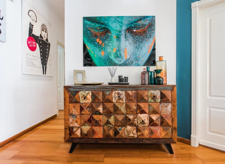 Interiorismo con estilo ecléctico. Mobiliario de madera y gran cuadro, realizado por los mejores interioristas de Valencia