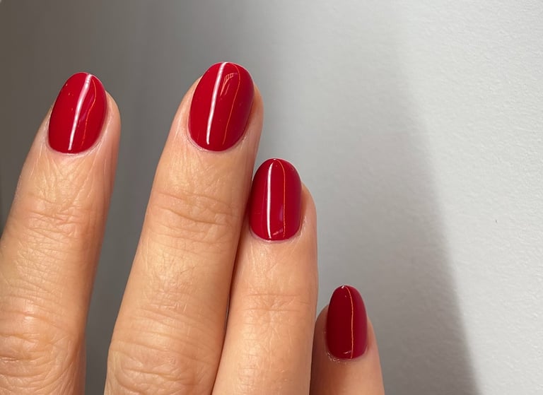 Image of perfectly manicured hands with bright red nails