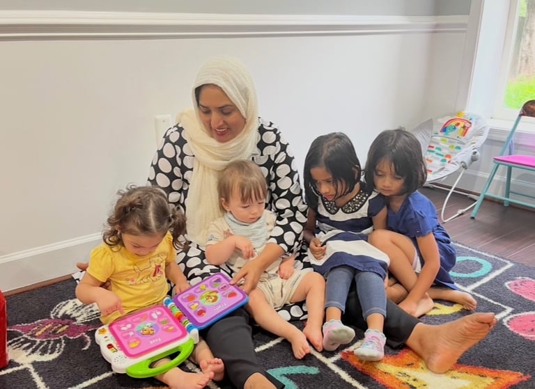 Daycare provider with children sitting together and reading an electronic book