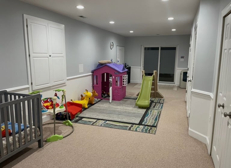 Daycare playroom with pink toy house and green slide