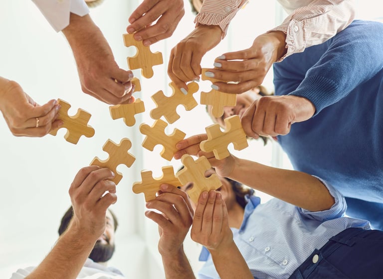Um grupo de pessoas segurando peças de quebra-cabeça