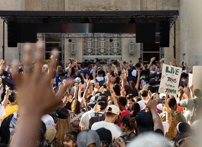 Group of people with hands raised during Houston Jesus March