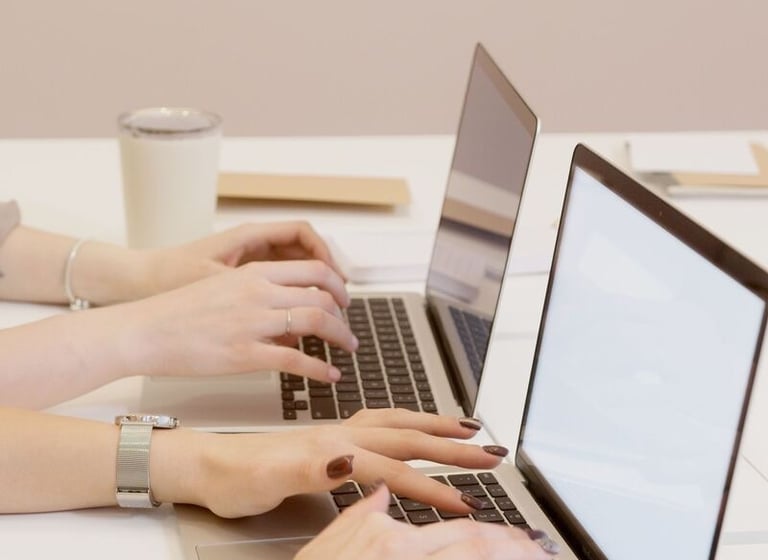photographie de deux femmes (mains) qui tapent sur le clavier de leur pc portable