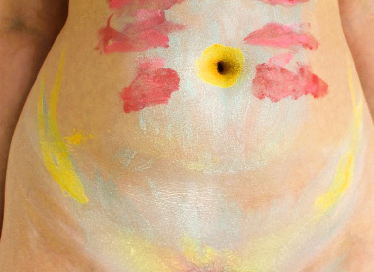 A digital photography artwork featuring a stomach with makeup applied to it