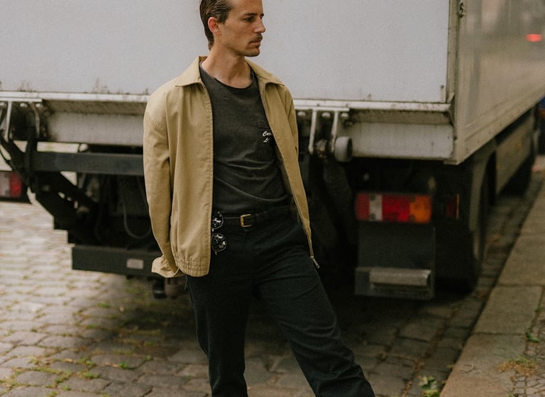 portrait of artist and designer Philipp Schäfer standing on a brick sidewalk next to a truck