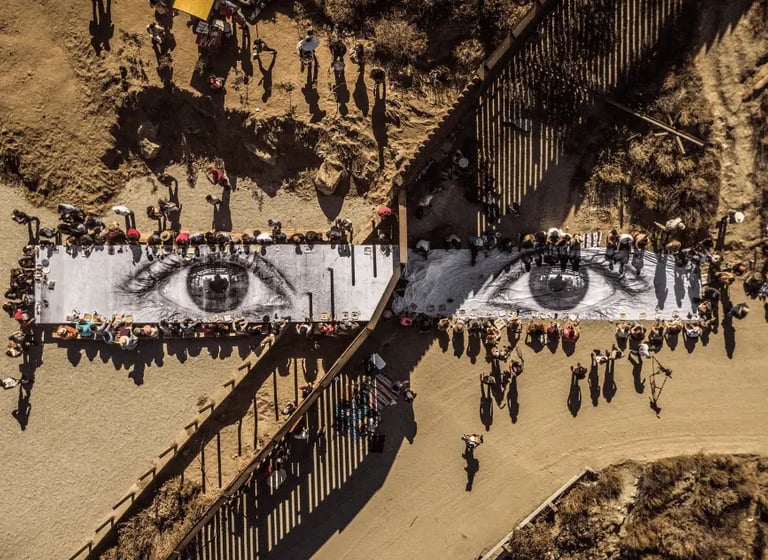 Vista aérea da instalação fotográfica de larga escala de JR, mostrando olhos gigantes impressos