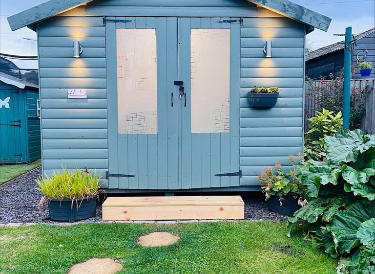 a small shed with a wooden shed and a garden