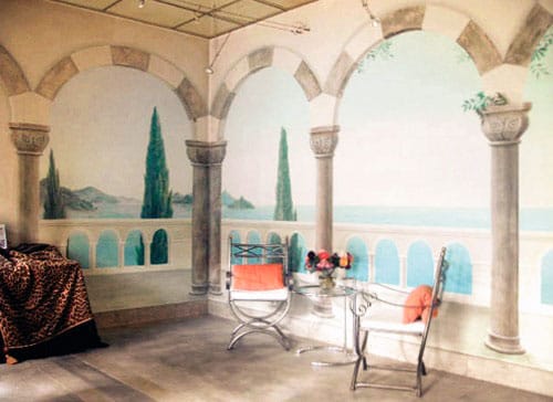 Interior mural with Moorish arches, terrace, cypress trees and ocean view.