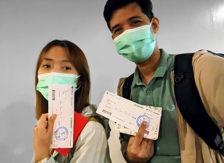 A couple wearing facemasks and holding tickets