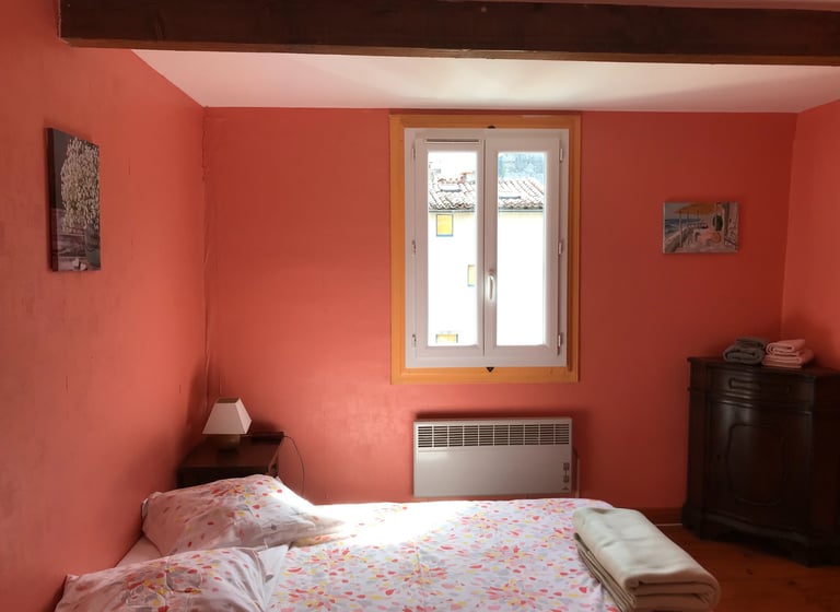 Vue sur le château historique de Quillan la nuit depuis la fenêtre ouverte d’une chambre 