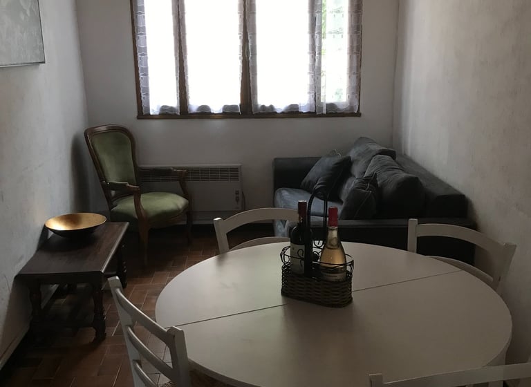 Salle à manger rustique à Quillan avec table ronde blanche et chaises en bois