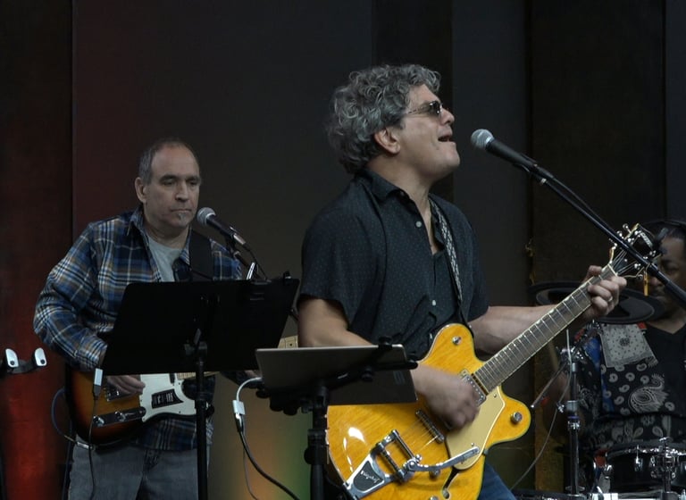 Sonny Cashbaugh playing guitar and singing into a microphone
