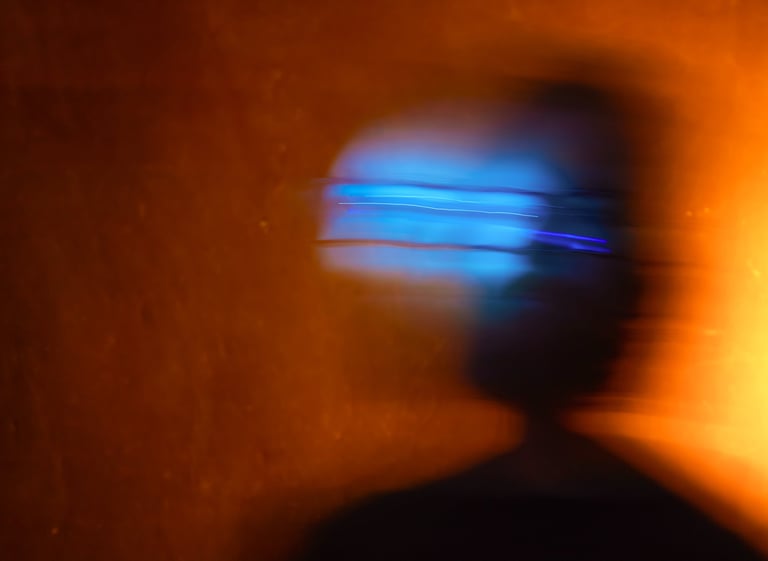 a person with a cell phone in front of a laptop