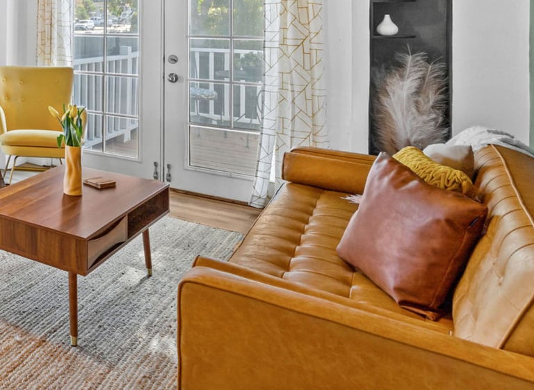 a living room with a couch, chairs, and a table