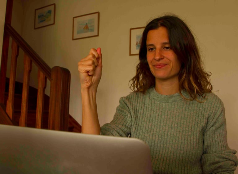 Laura Capit sitting at a table with a laptop computer