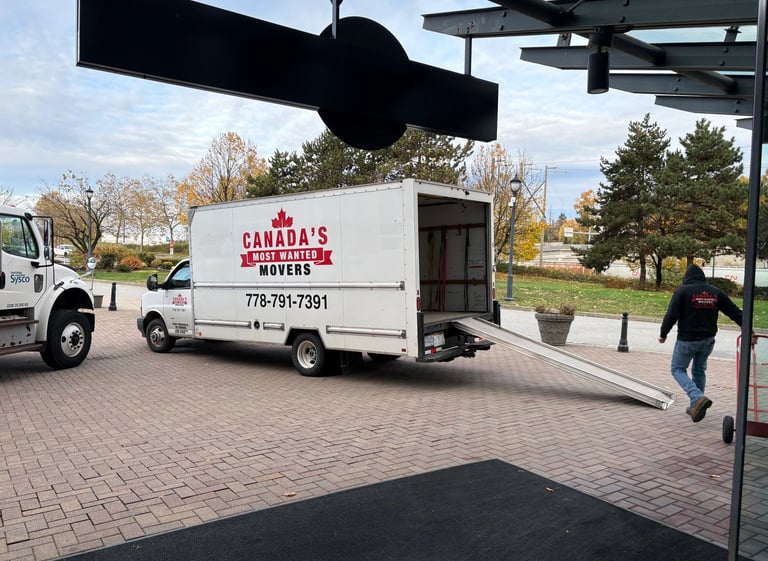 Canada’s Most Wanted Movers unloading at a commercial property in Coquitlam with ramp extended.