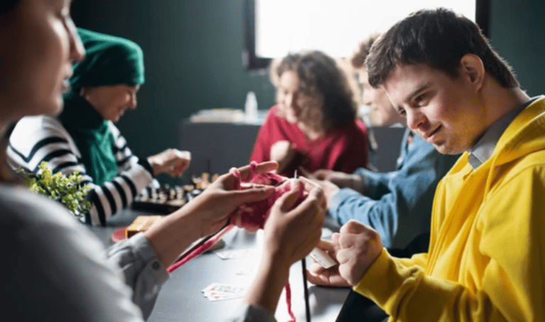 NDIS participants and support workers engaging in a group arts and crafts activity