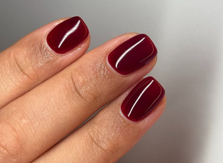 Image of perfectly manicured hands with dark red nails