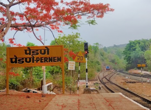 a pernem train station with a sign board which says, stop and go to other station