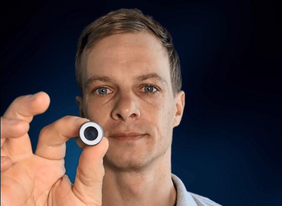 A close up of a male person holding an EQ Tool into the camera