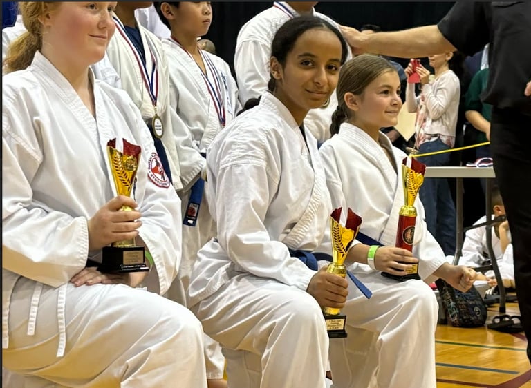 a group of people sitting on a bench with trophies