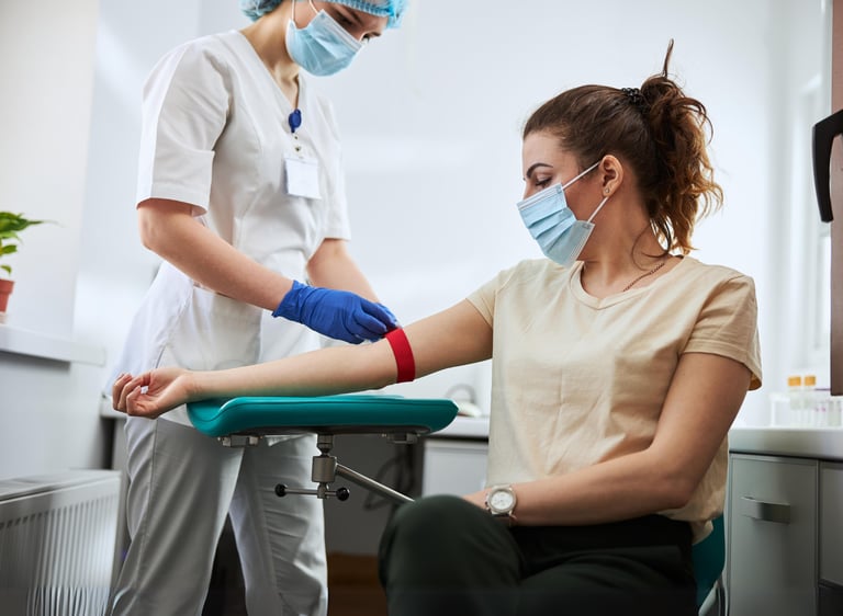 a woman preparing to get blood drawn by a nurse to perform labs