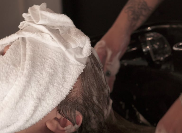 a man getting his hair washed in a bowl