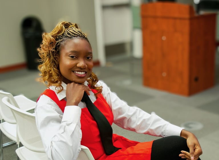 Iheoma Uzomba Oma is Loud Professional headshot in red and white