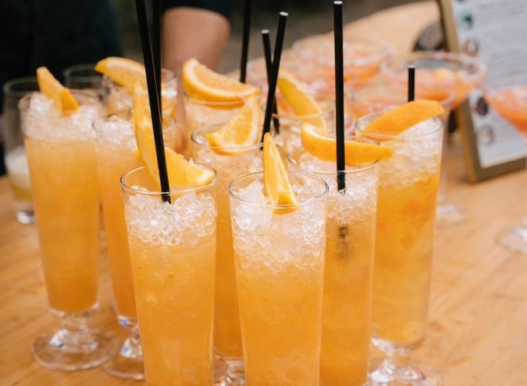Refreshing tropical cocktails with crushed ice and citrus slices served at an outdoor bar.
