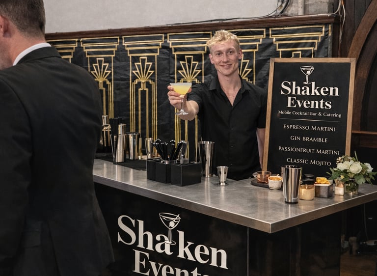 Professional bartender serving a yellow cocktail at a Shaken Events mobile bar for a formal event.