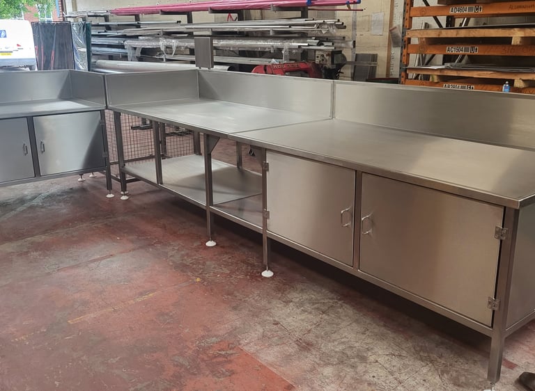 Custom industrial stainless steel prep tables and storage cabinets for commercial kitchens.