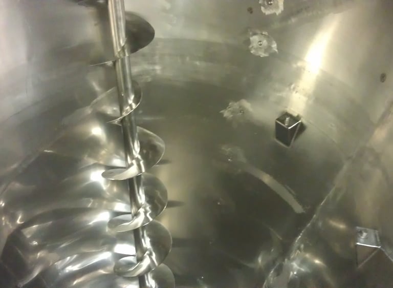 Industrial stainless steel ribbon blender with helical screw agitator for mixing powders and solids.