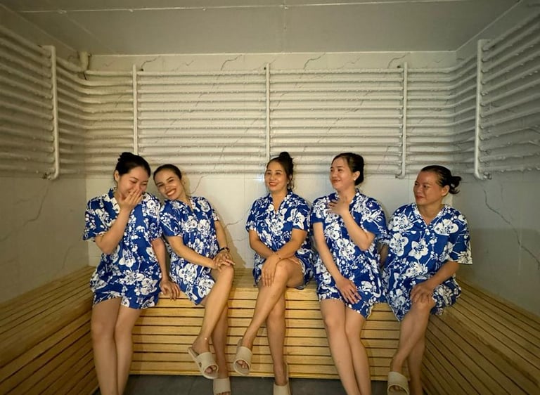 a group of women in blue dresses sitting on a bench ina cold room