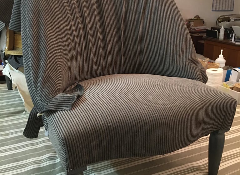 Chauffeuse recouverte d'un tissu en train d'être posé