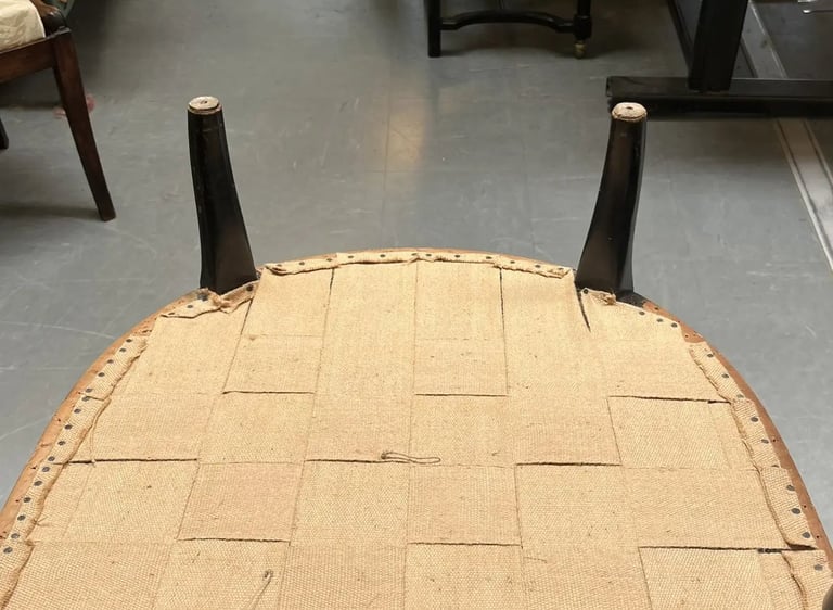 Un fauteuil crapaud à l'envers pour montrer le sangle sur le fond