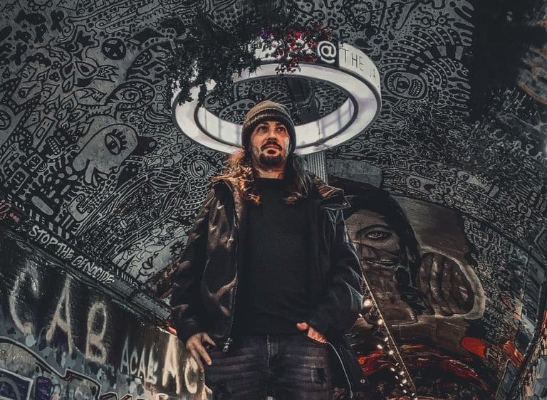 a man with long hair and a beard wearing a black jacket