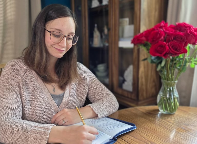 a woman sitting at a table with a pen and notebook