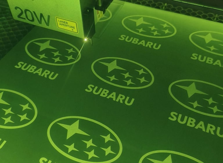 Graveuse laser XTOOL en action, gravure de logos Subaru sur médium mélaminé graphite